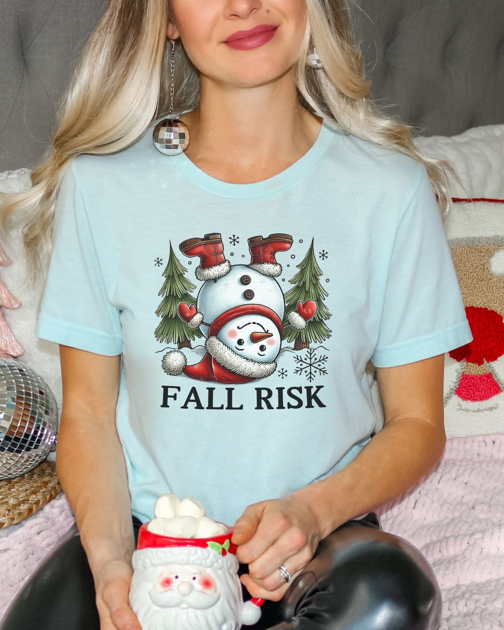 Girl wearing heather ice blue t-shirt with snowman falling down