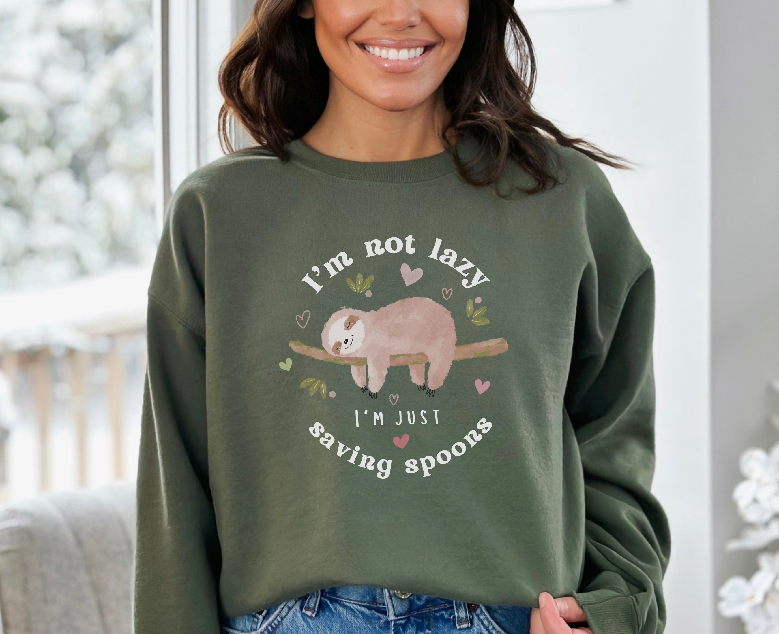 Woman wearing military green sweatshirt with sleeping sloth on it