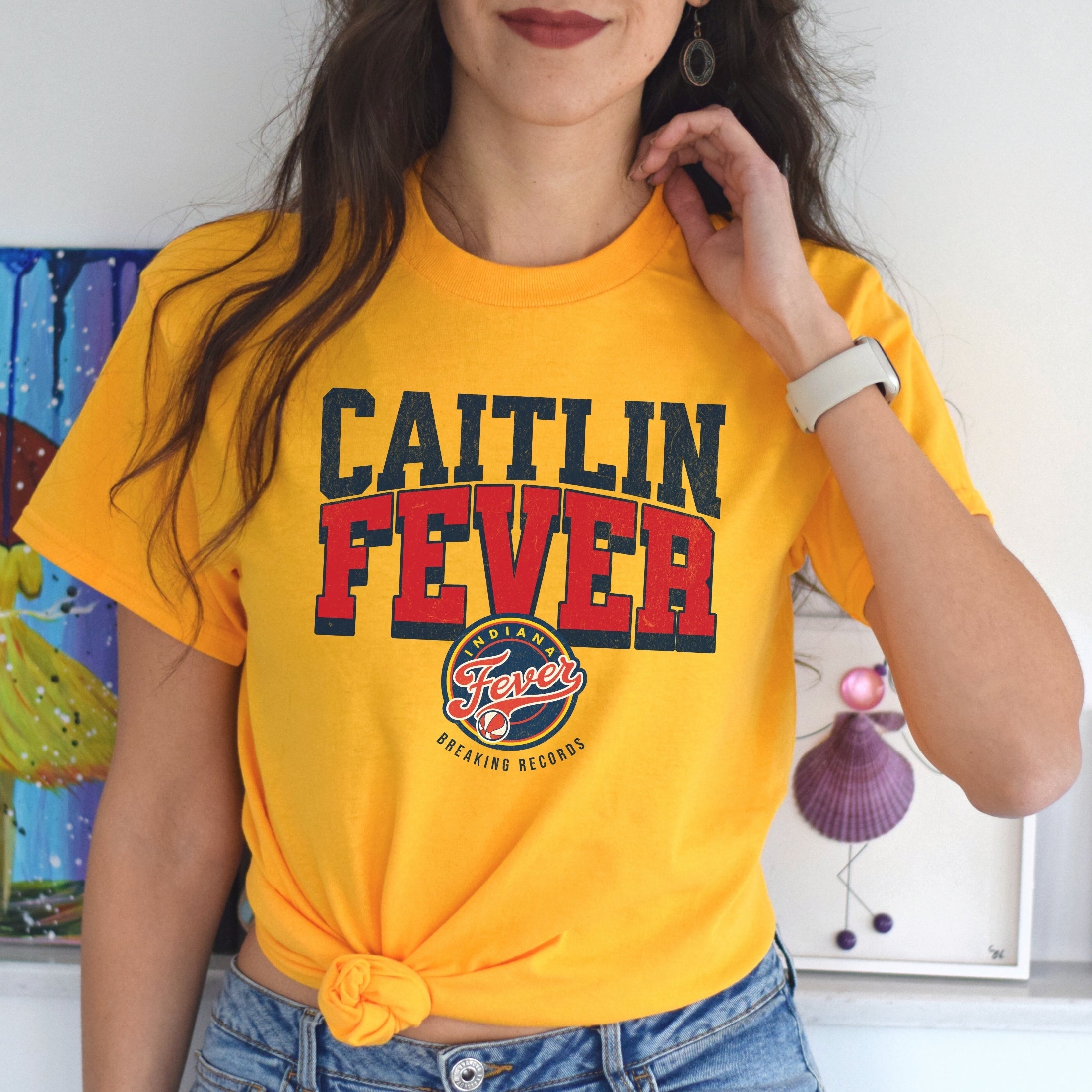 Woman wearing gold Caitlin Fever shirt