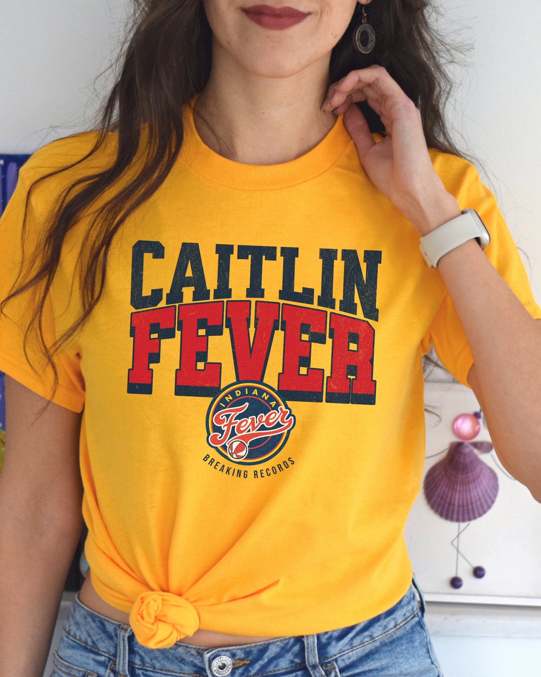 Woman wearing gold Caitlin Fever shirt