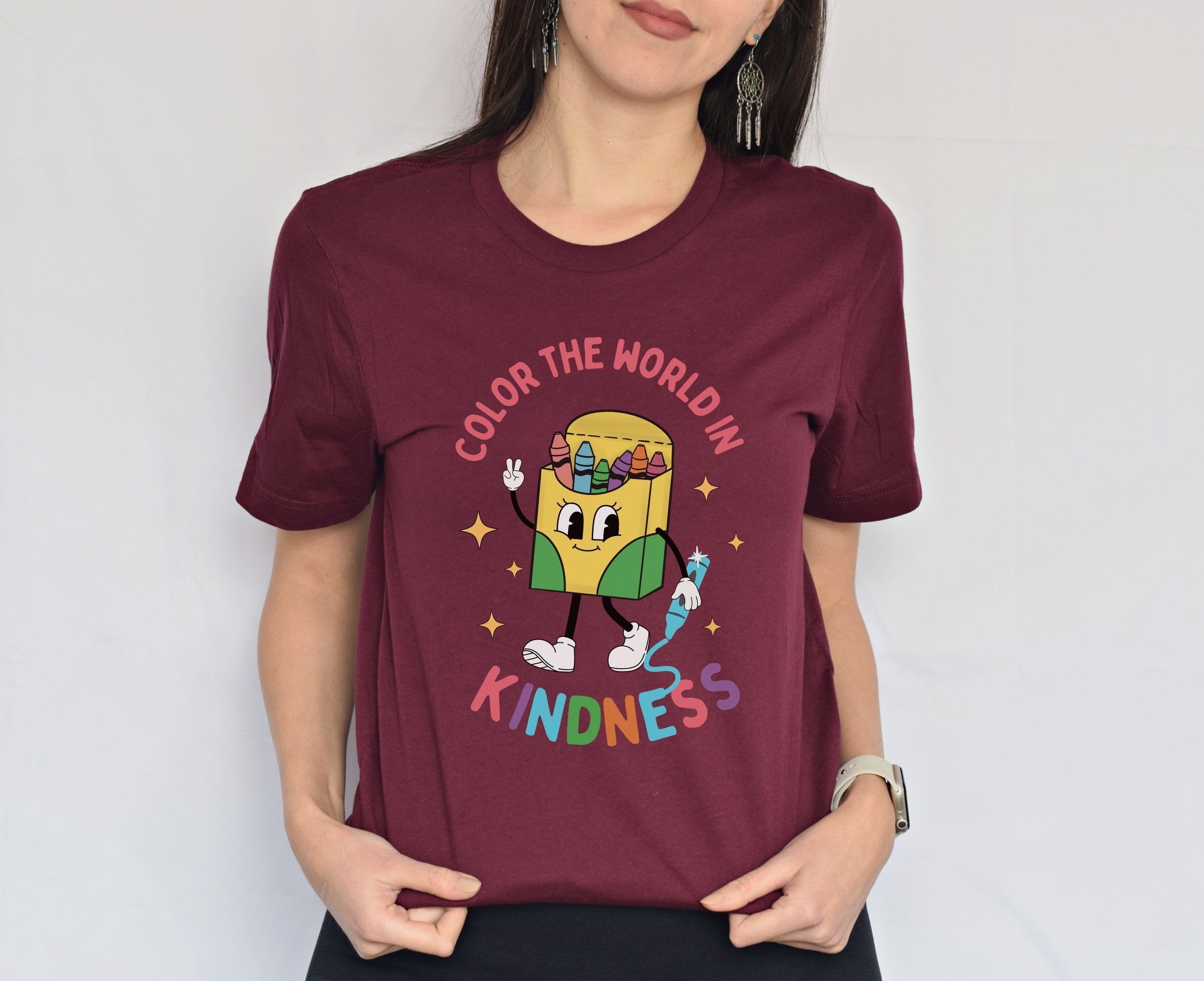 Woman wearing maroon color the world in kindness shirt