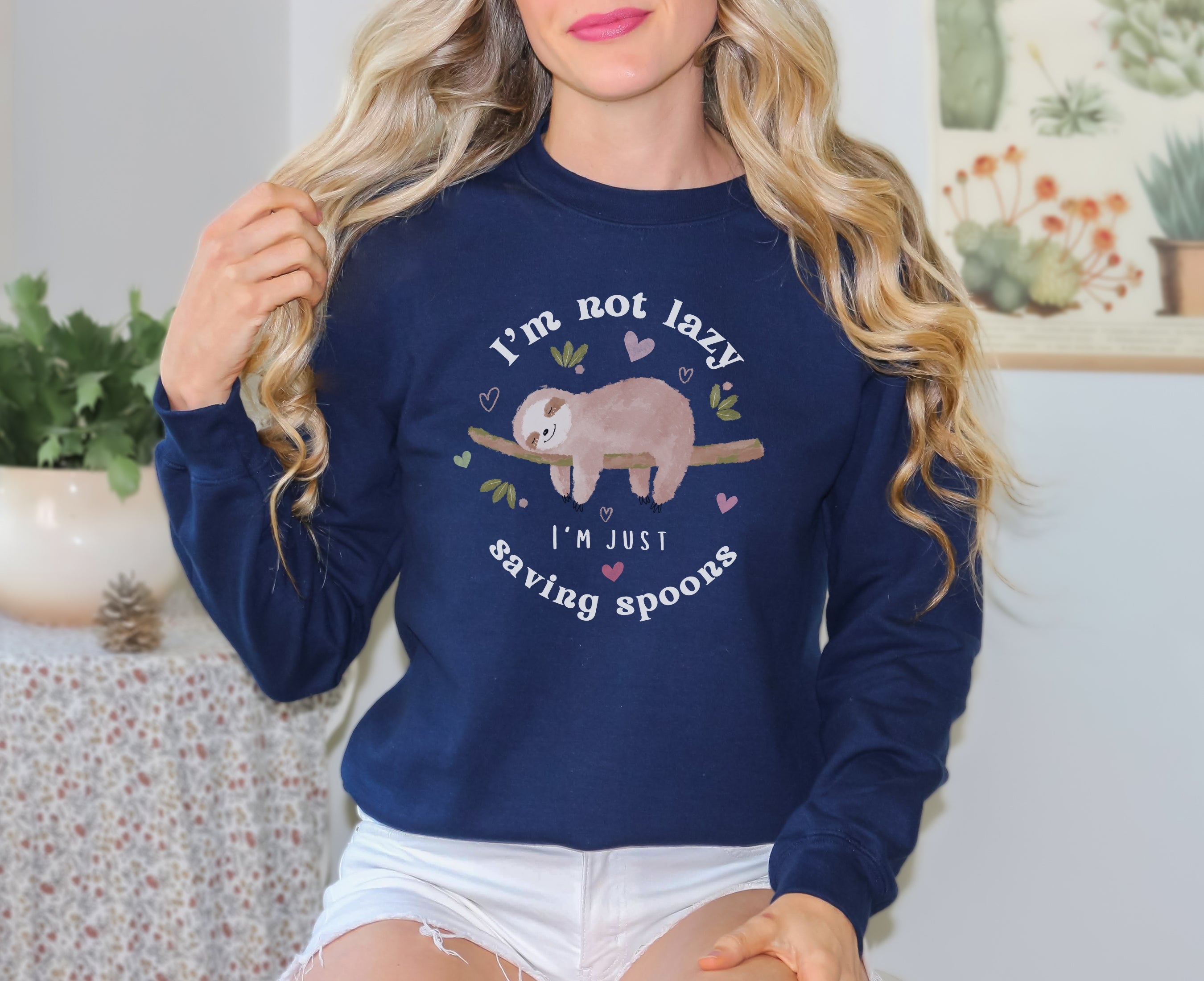 Woman wearing navy sweatshirt with sleeping sloth on it