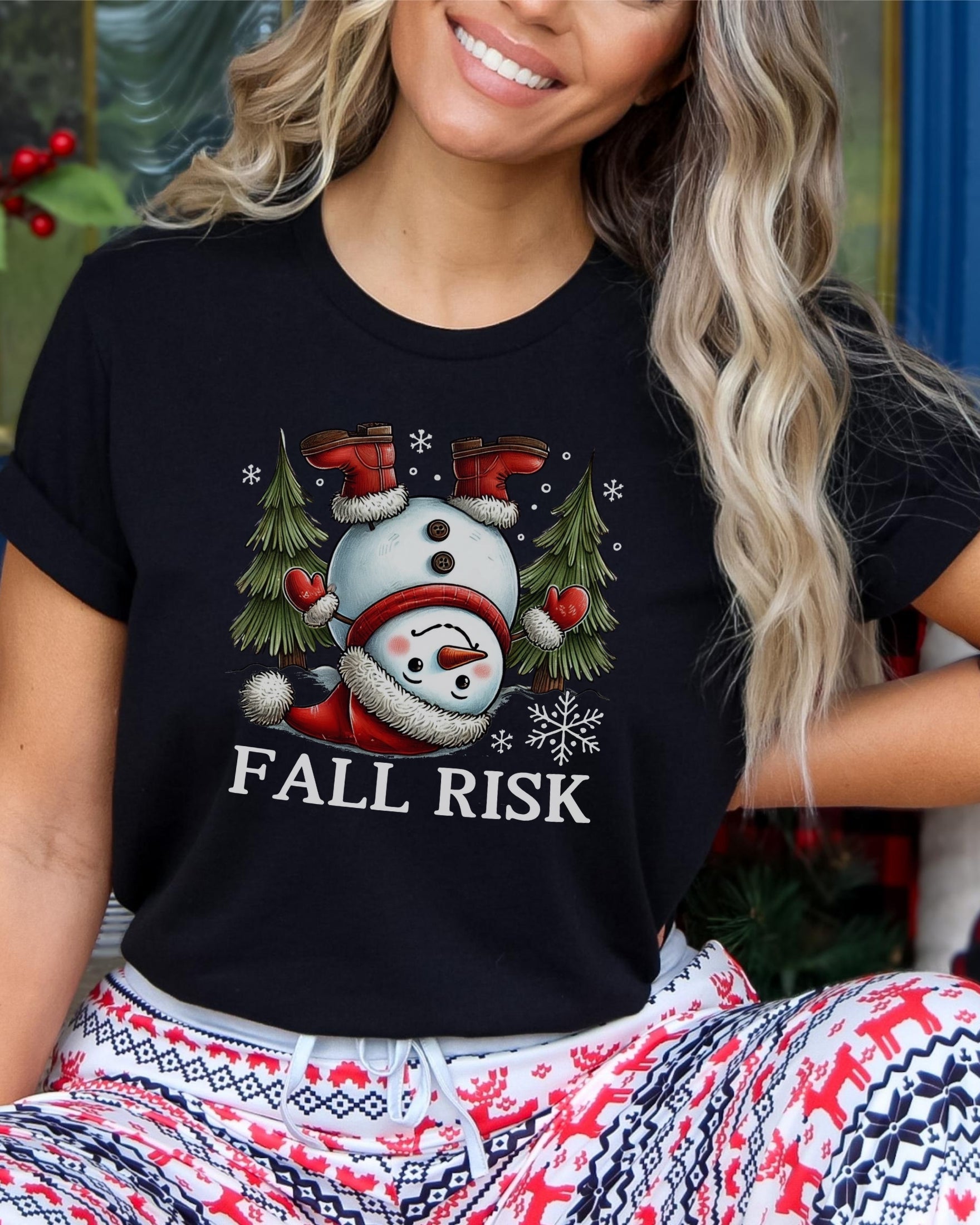 Girl wearing black t-shirt with snowman upside down saying fall risk