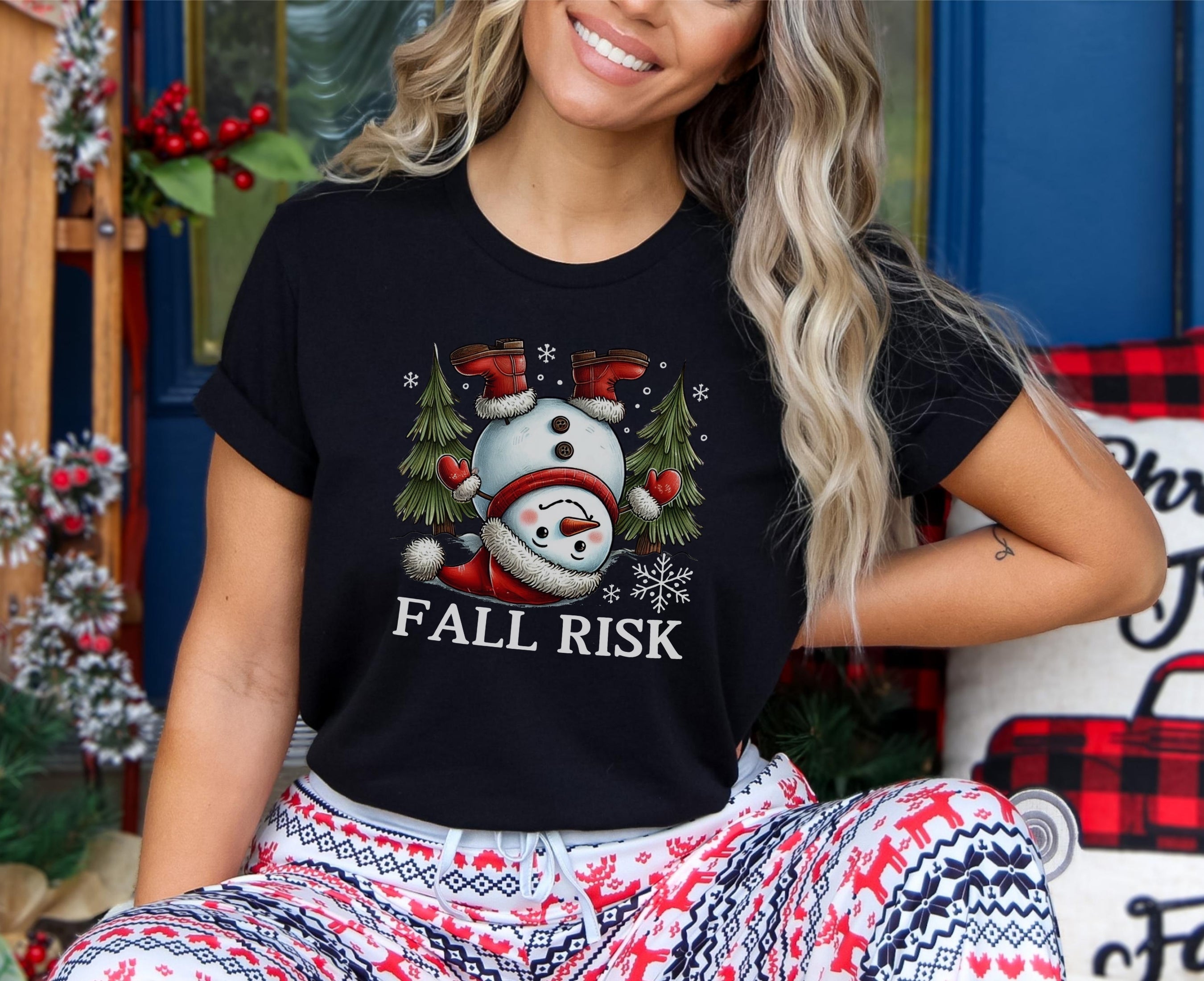 Girl wearing black t-shirt with snowman upside down saying fall risk