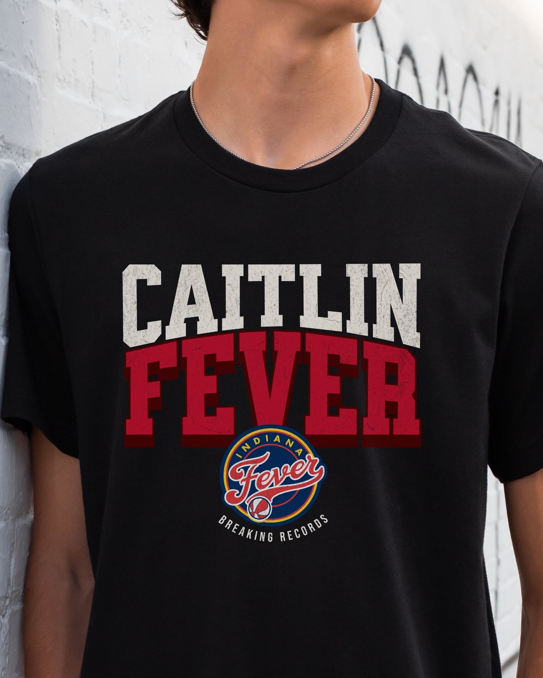 Man wearing black Caitlin Fever Record Breaking shirt