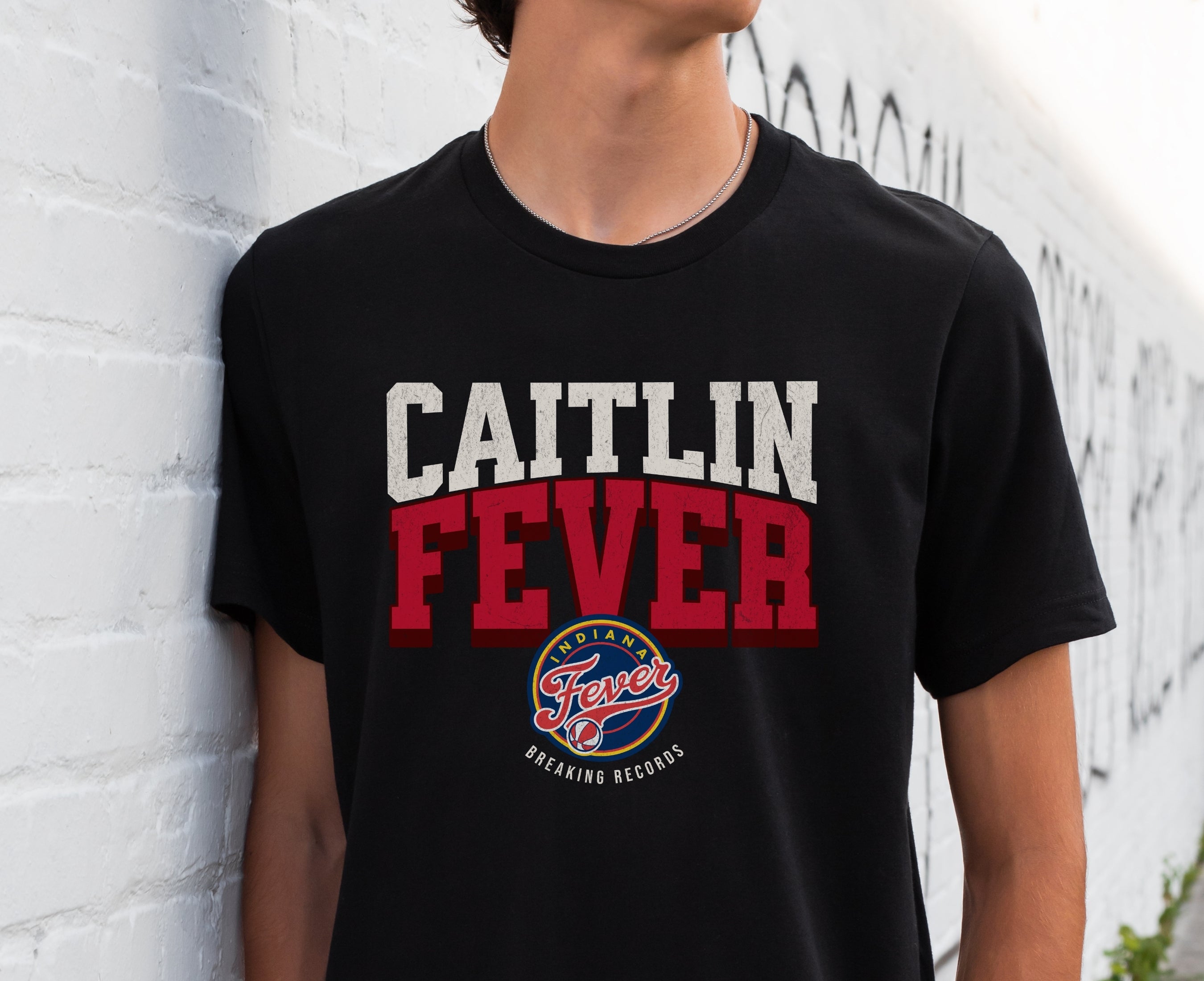 Man wearing black Caitlin Fever Record Breaking shirt