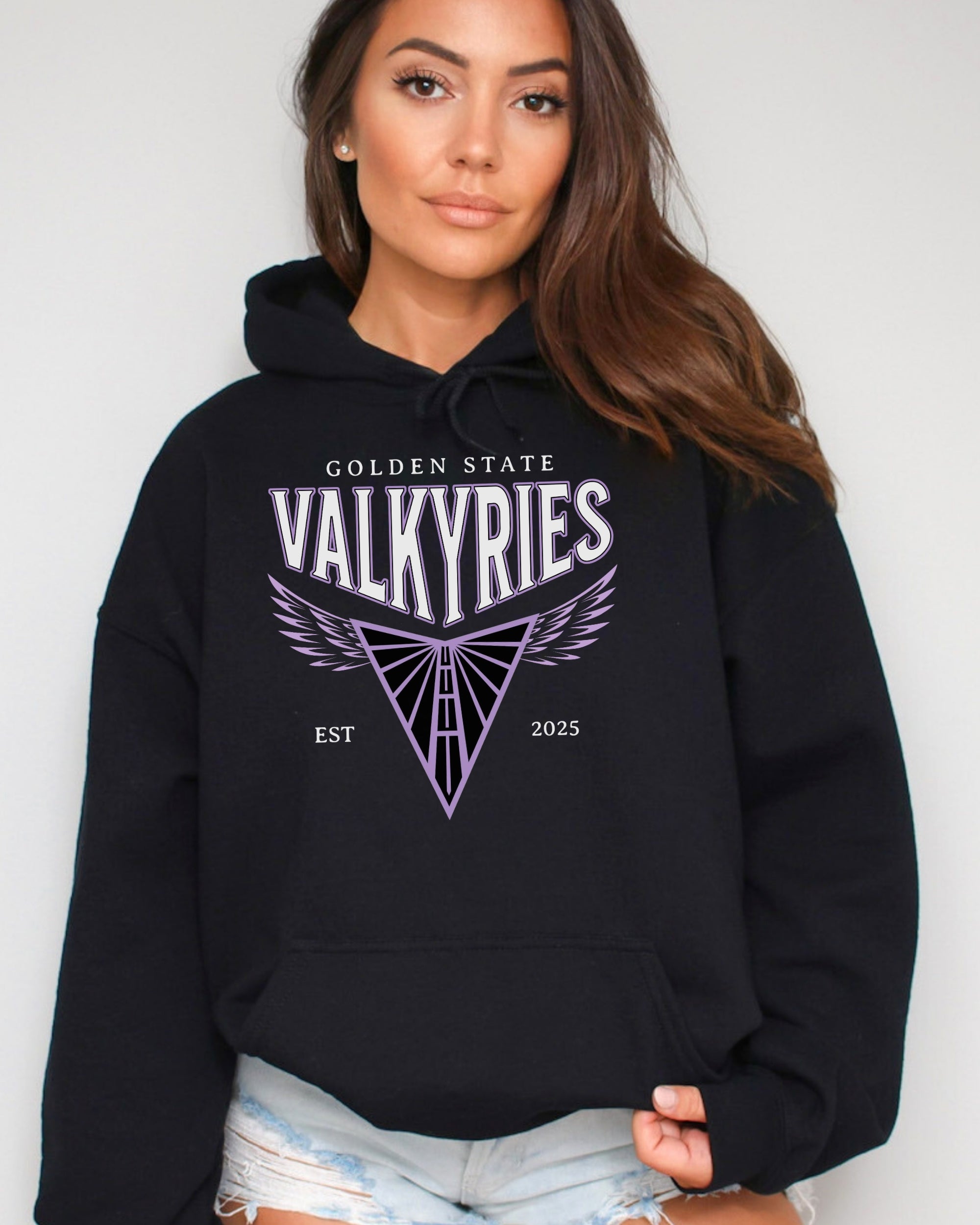 Woman wearing a black hoodie with 'Golden State Valkyries' logo on a plain background