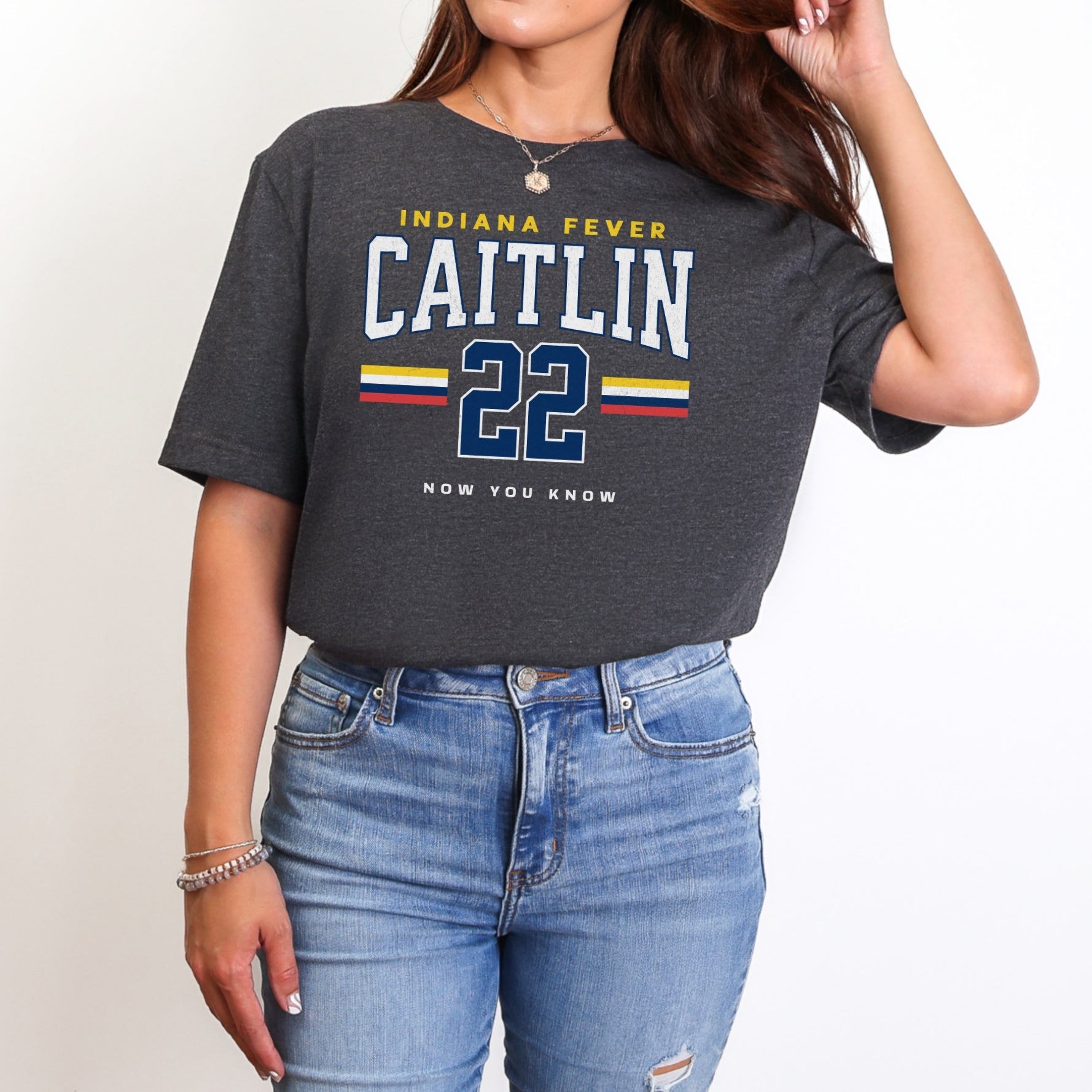 Person wearing a dark gray t-shirt with 'Indiana Fever Caitlin 22' text, standing against a plain background.