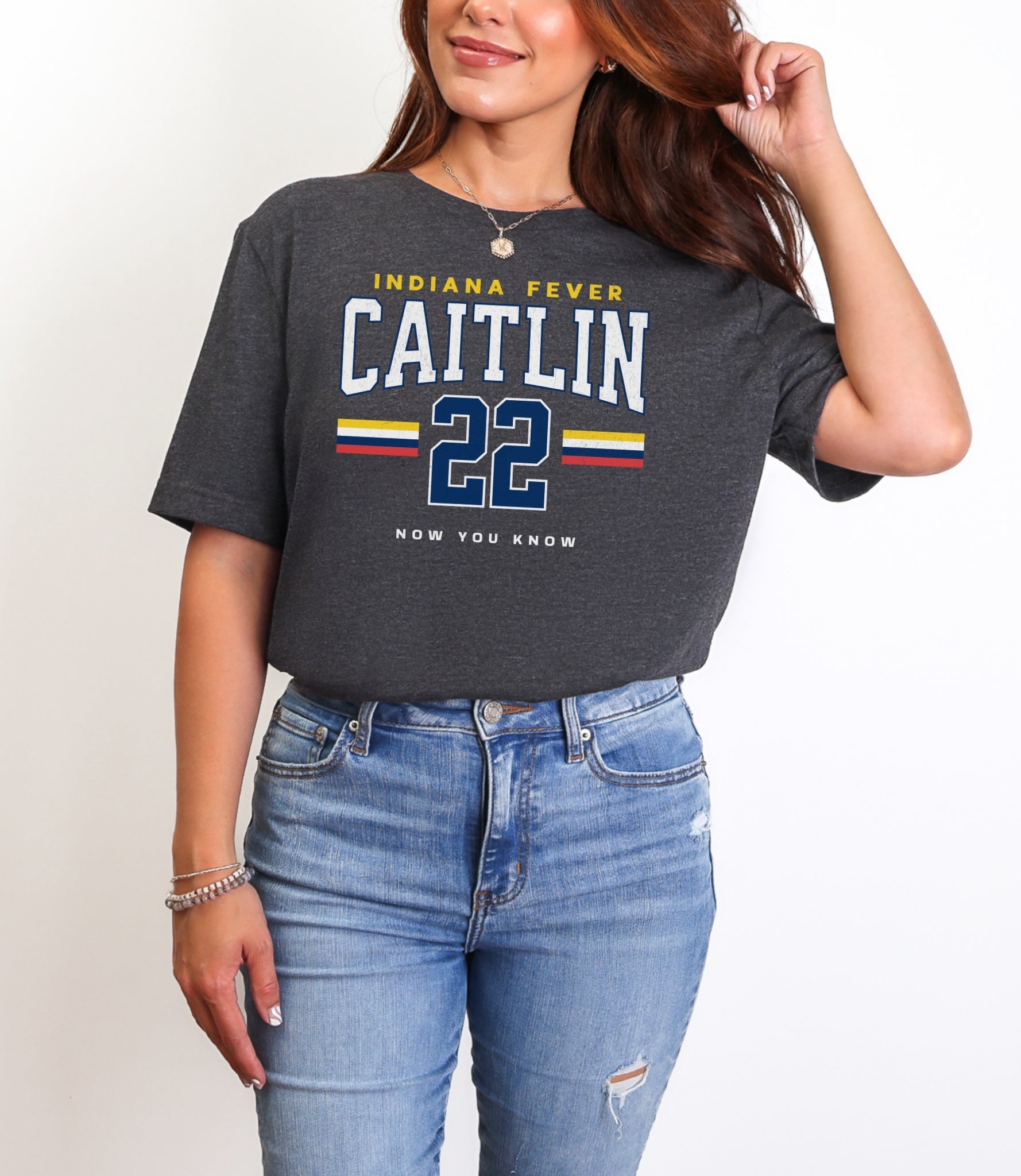 Person wearing a dark gray t-shirt with 'Indiana Fever Caitlin 22' text, standing against a plain background.
