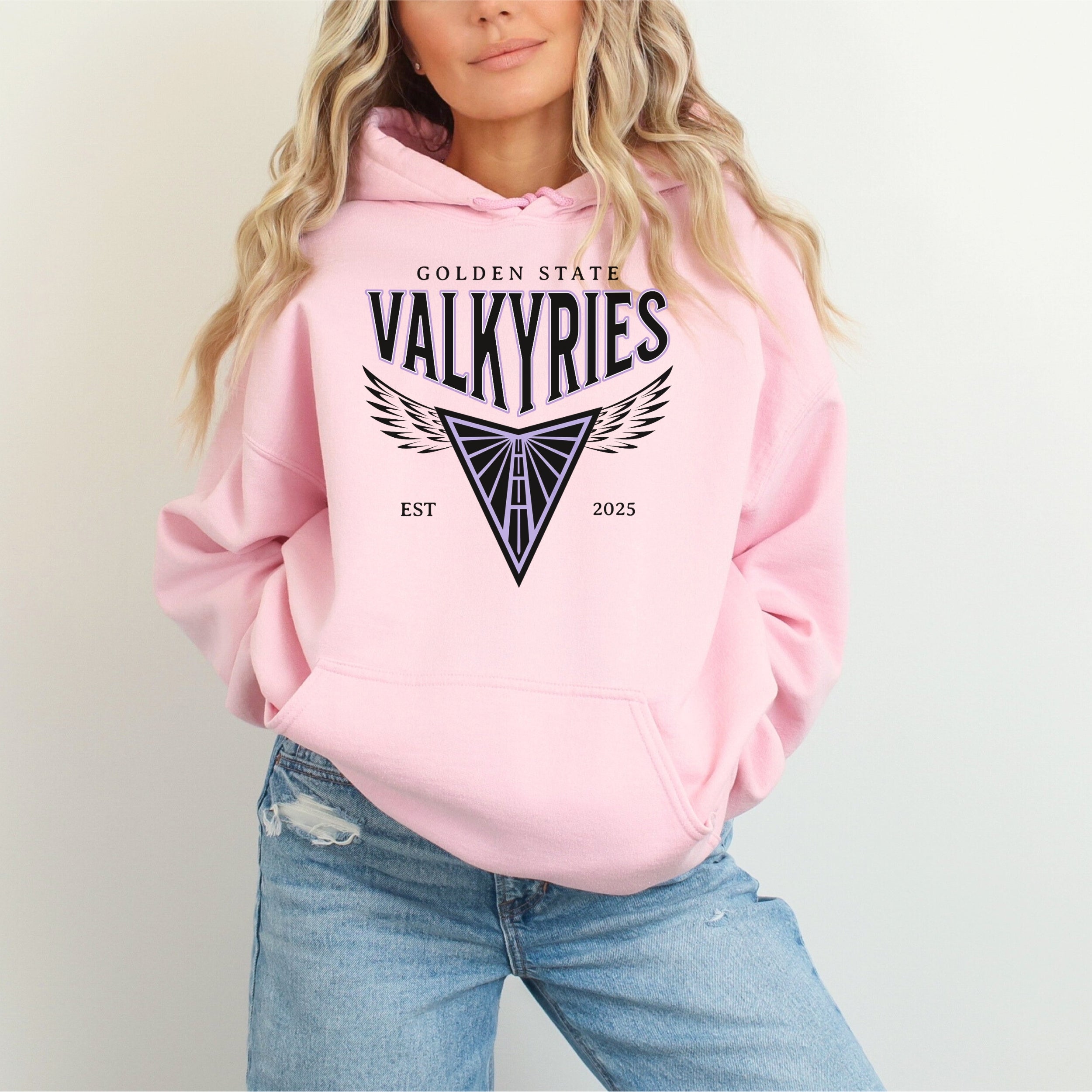 Person wearing a pink hoodie with 'Golden State Valkyries' logo on a plain background