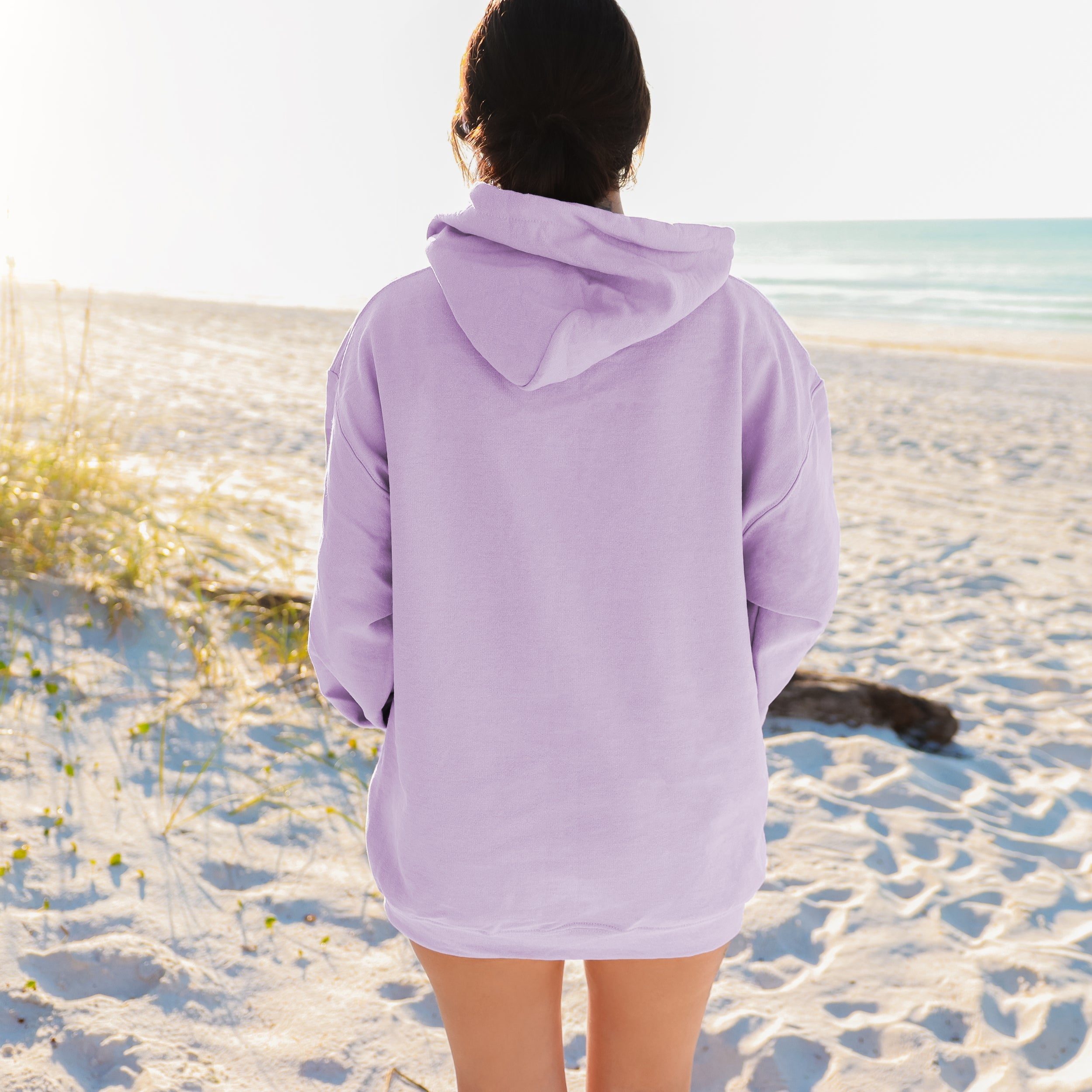 Person wearing a lavender hoodie on a beach