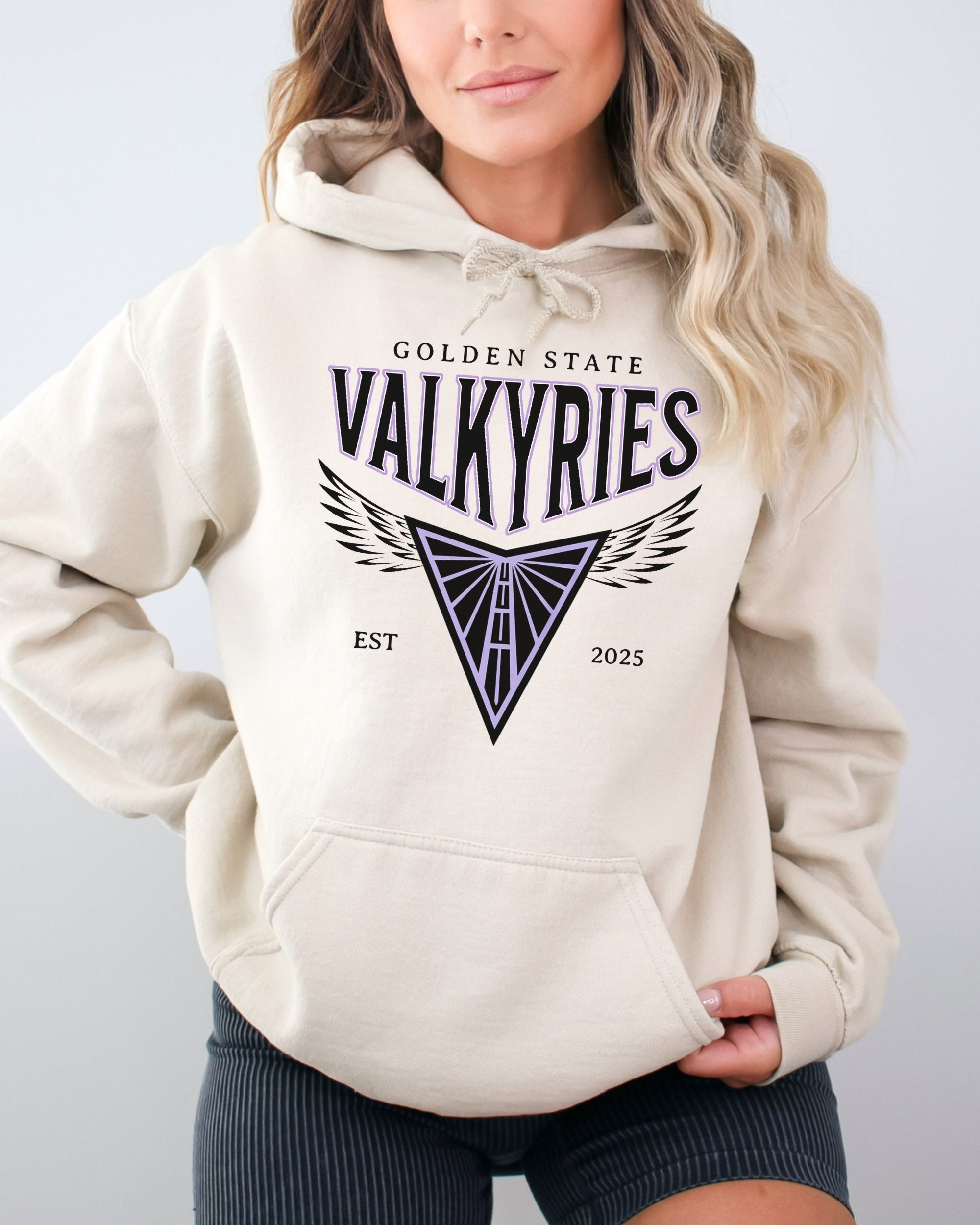 Person wearing a beige hoodie with 'Golden State Valkyries' logo on a plain background