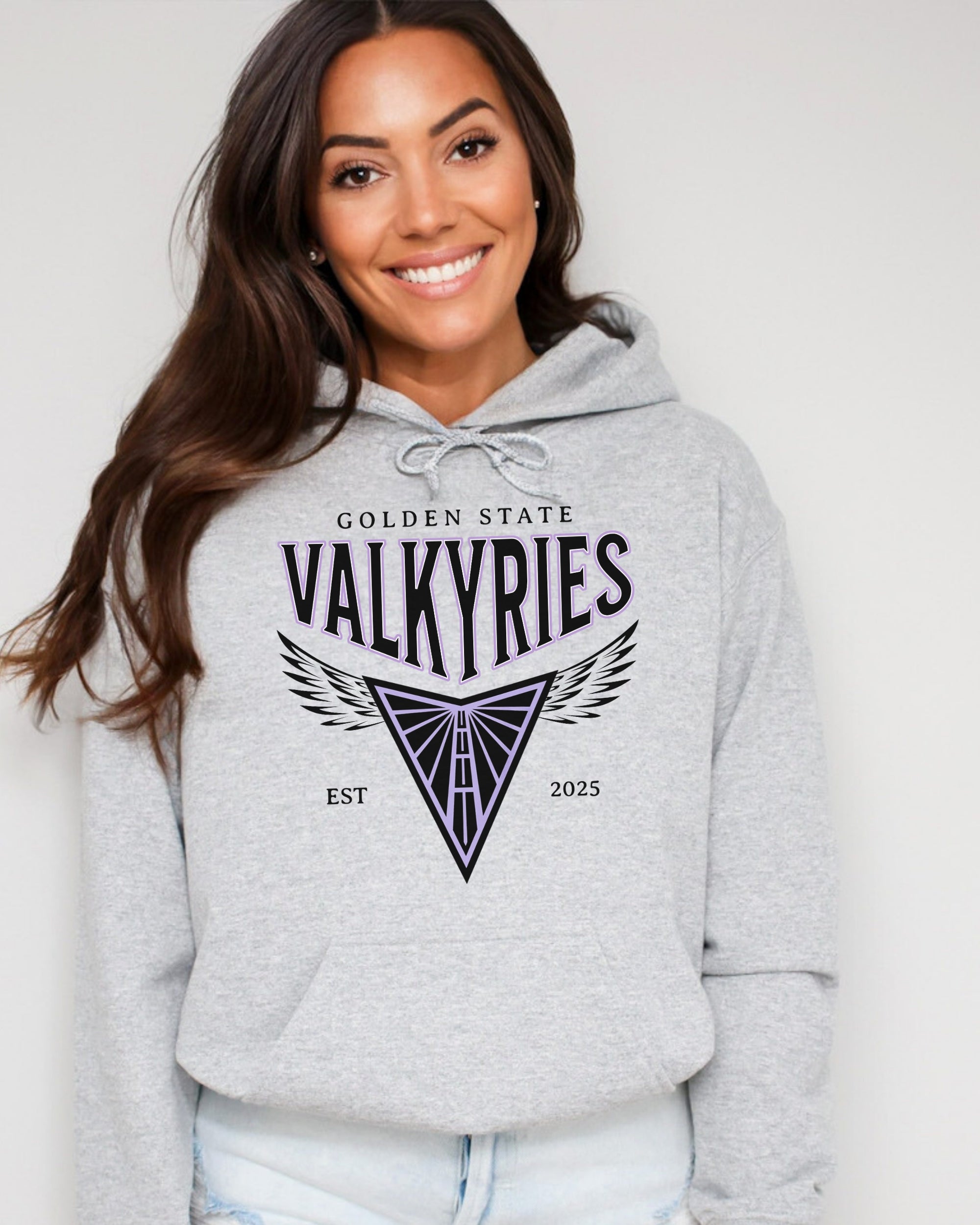 Woman wearing a gray hoodie with 'Golden State Valkyries' logo on a white background