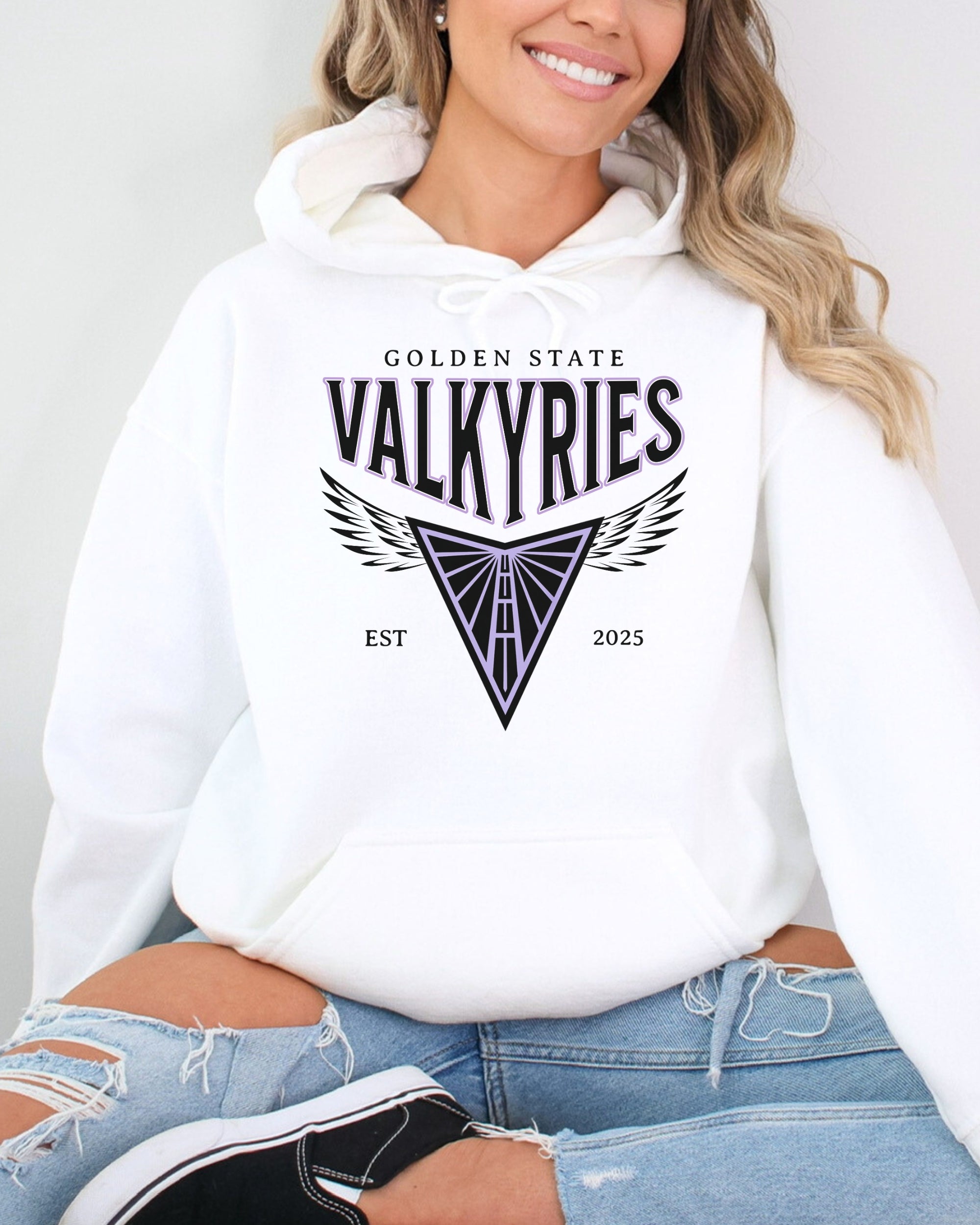 Person wearing a white hoodie with 'Golden State Valkyries' design on a plain background