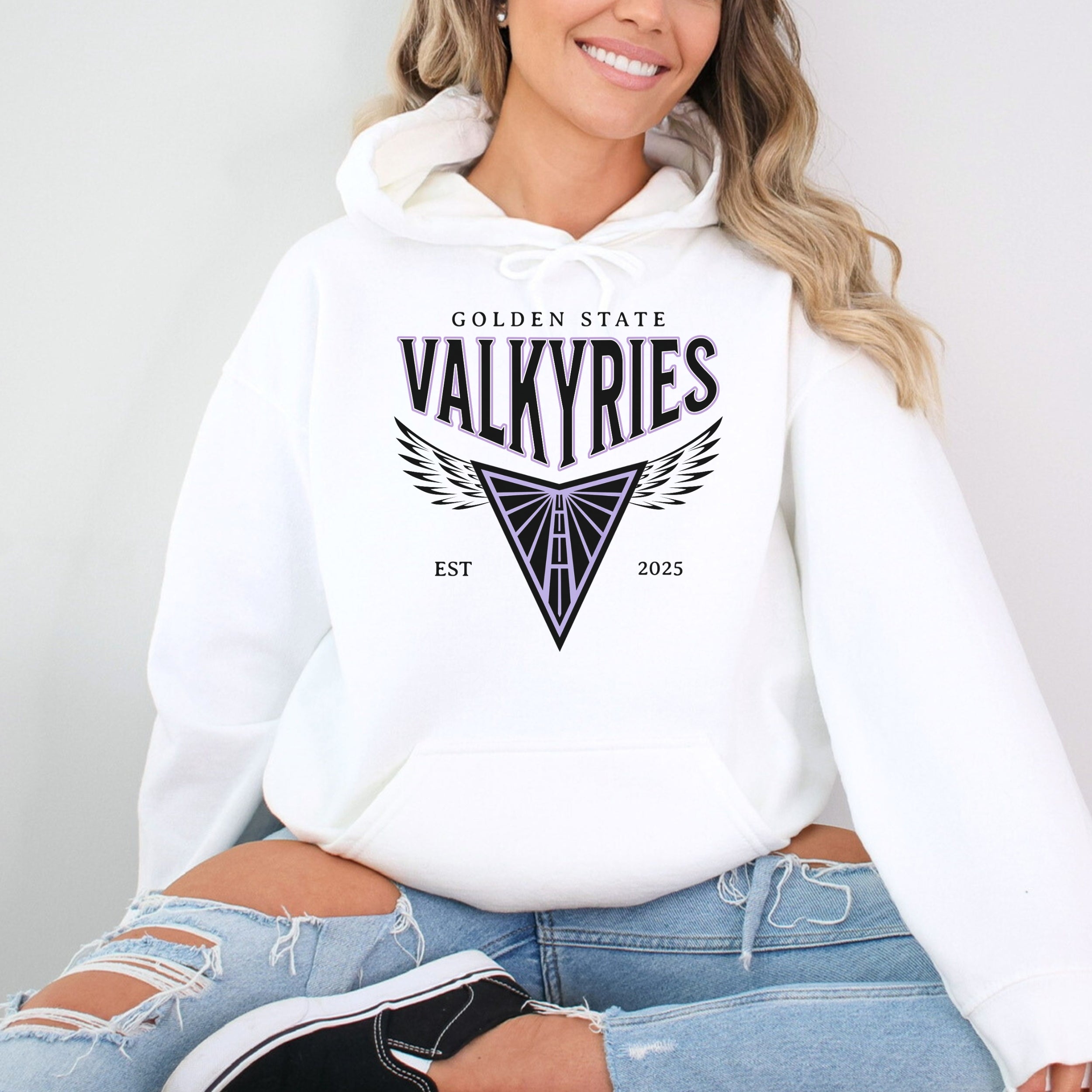 Person wearing a white hoodie with 'Golden State Valkyries' design on a plain background