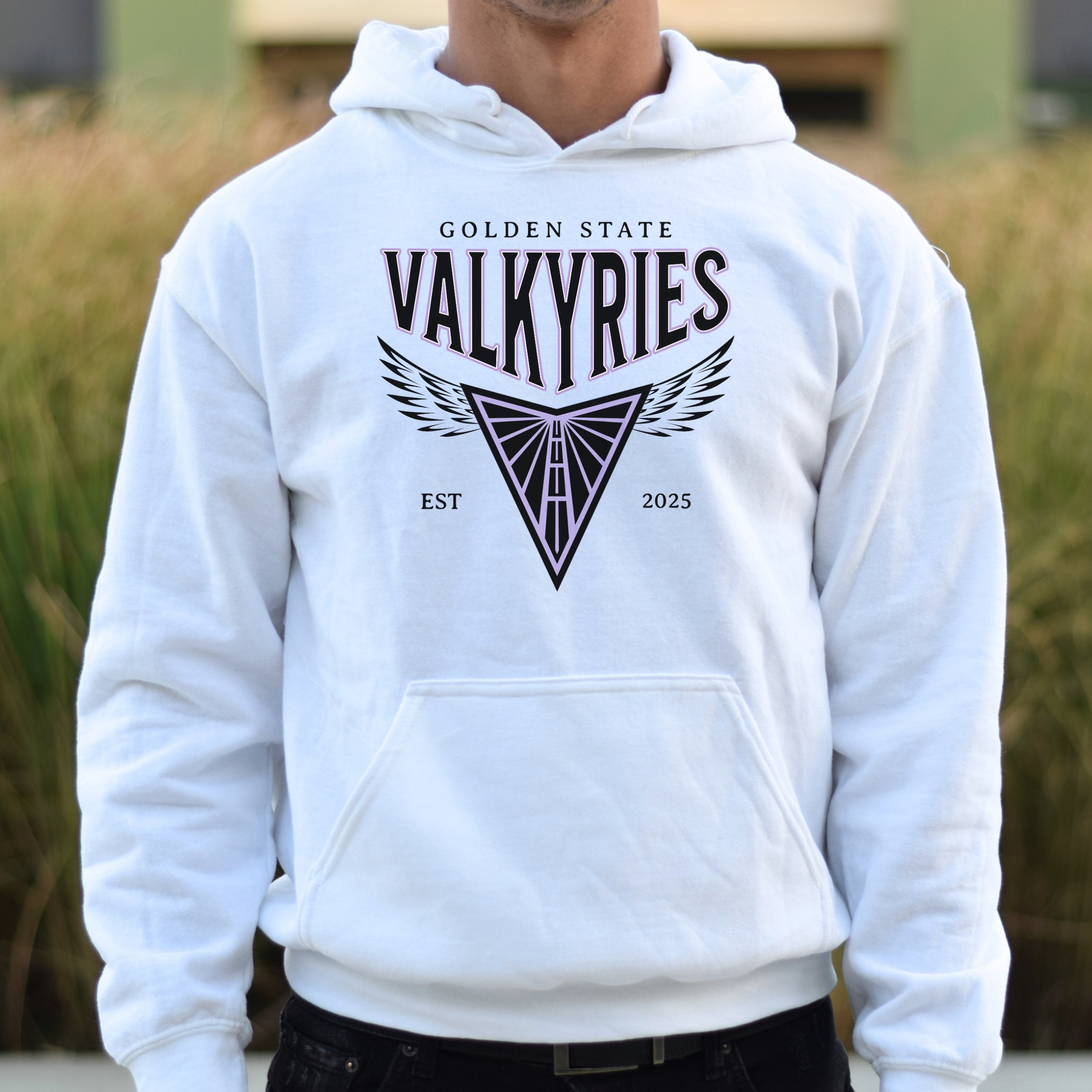 White hoodie with 'Golden State Valkyries' design on a blurred outdoor background