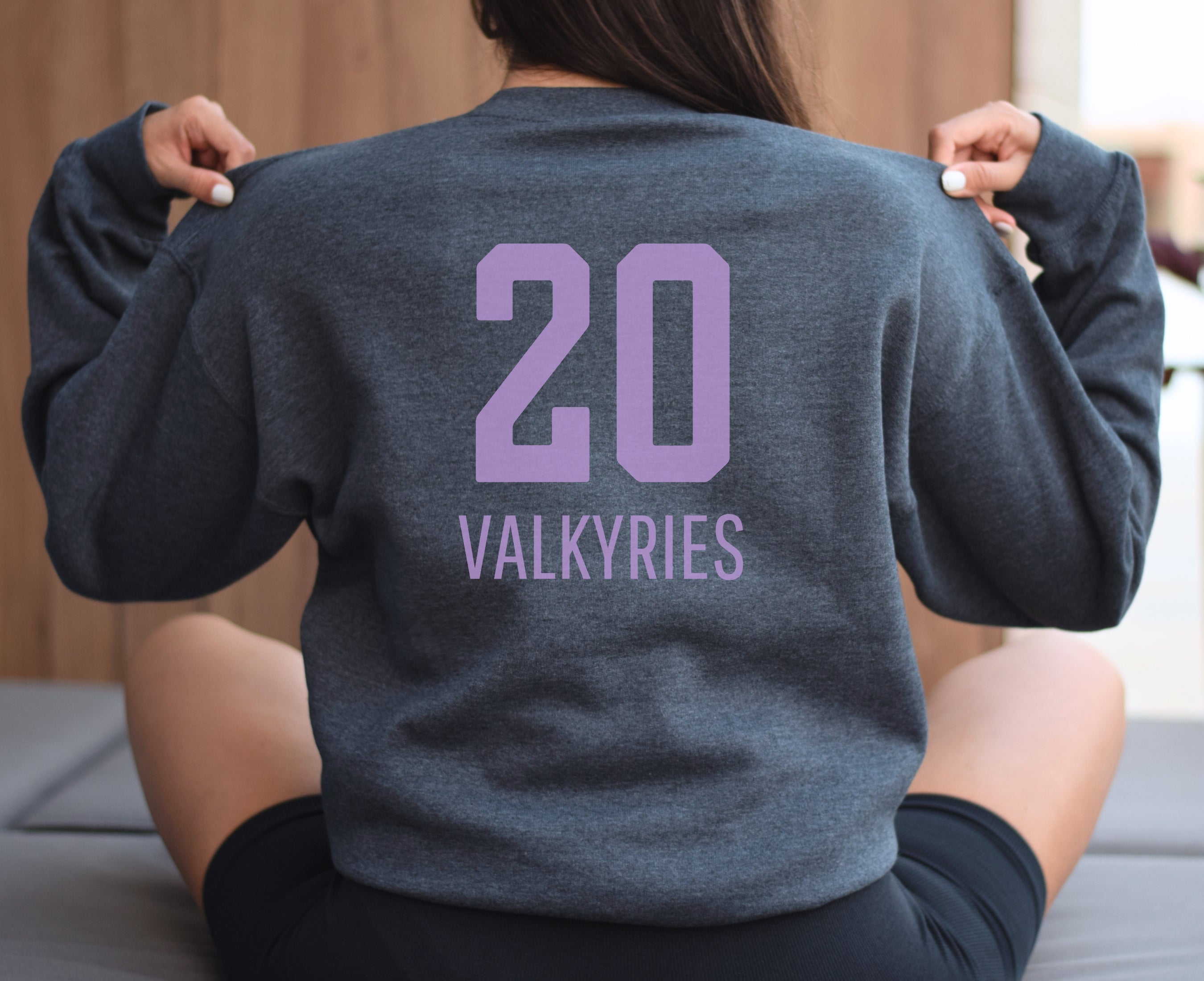 Girl wearing dark heather Valkyries 20 sweatshirt