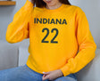 Girl wearing gold Indiana 22 sweatshirt