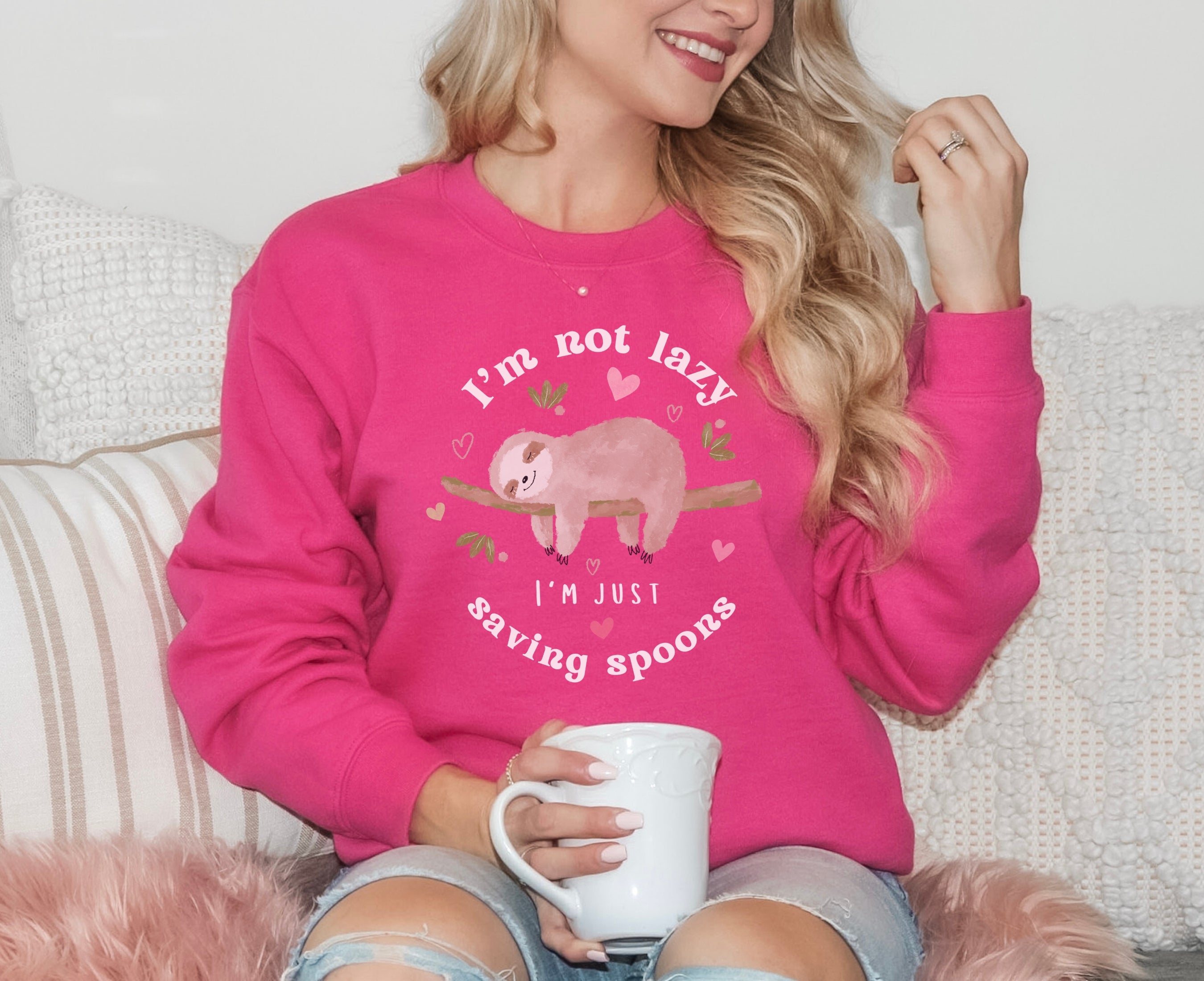 Woman wearing heliconia sweatshirt with sleeping sloth on it