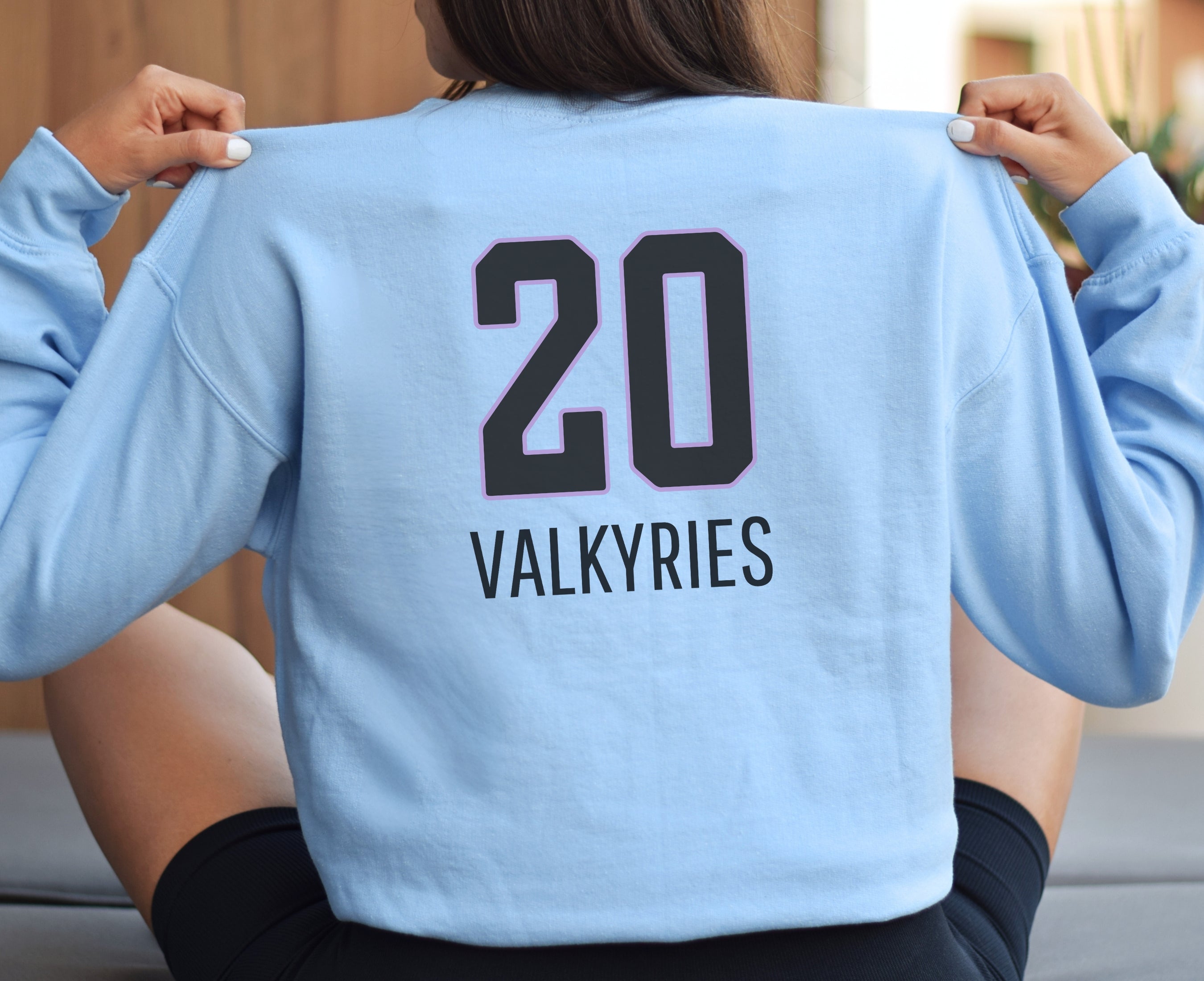 Girl wearing light blue Valkyries 20 sweatshirt