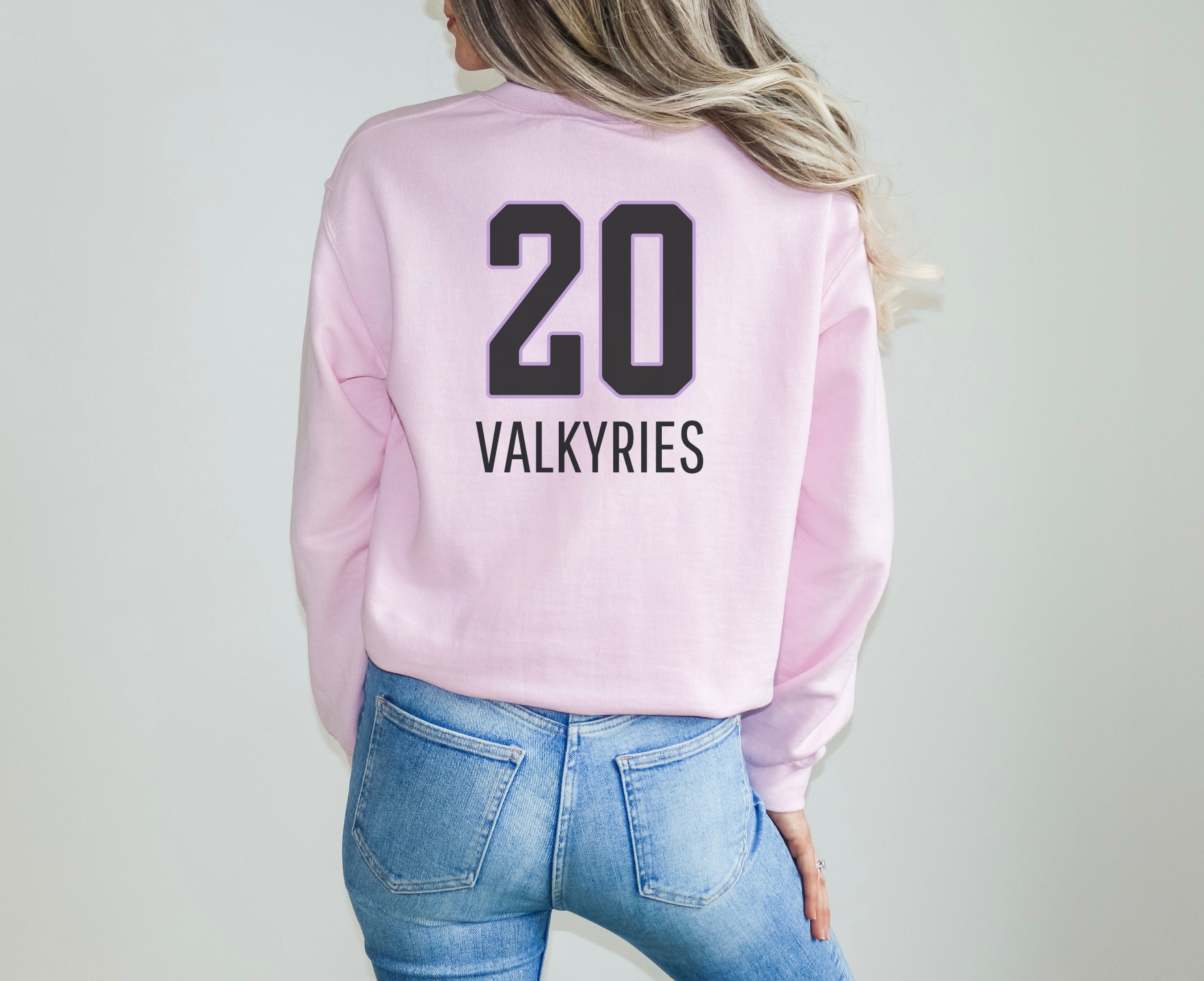 Girl wearing light pink Valkyries 20 sweatshirt