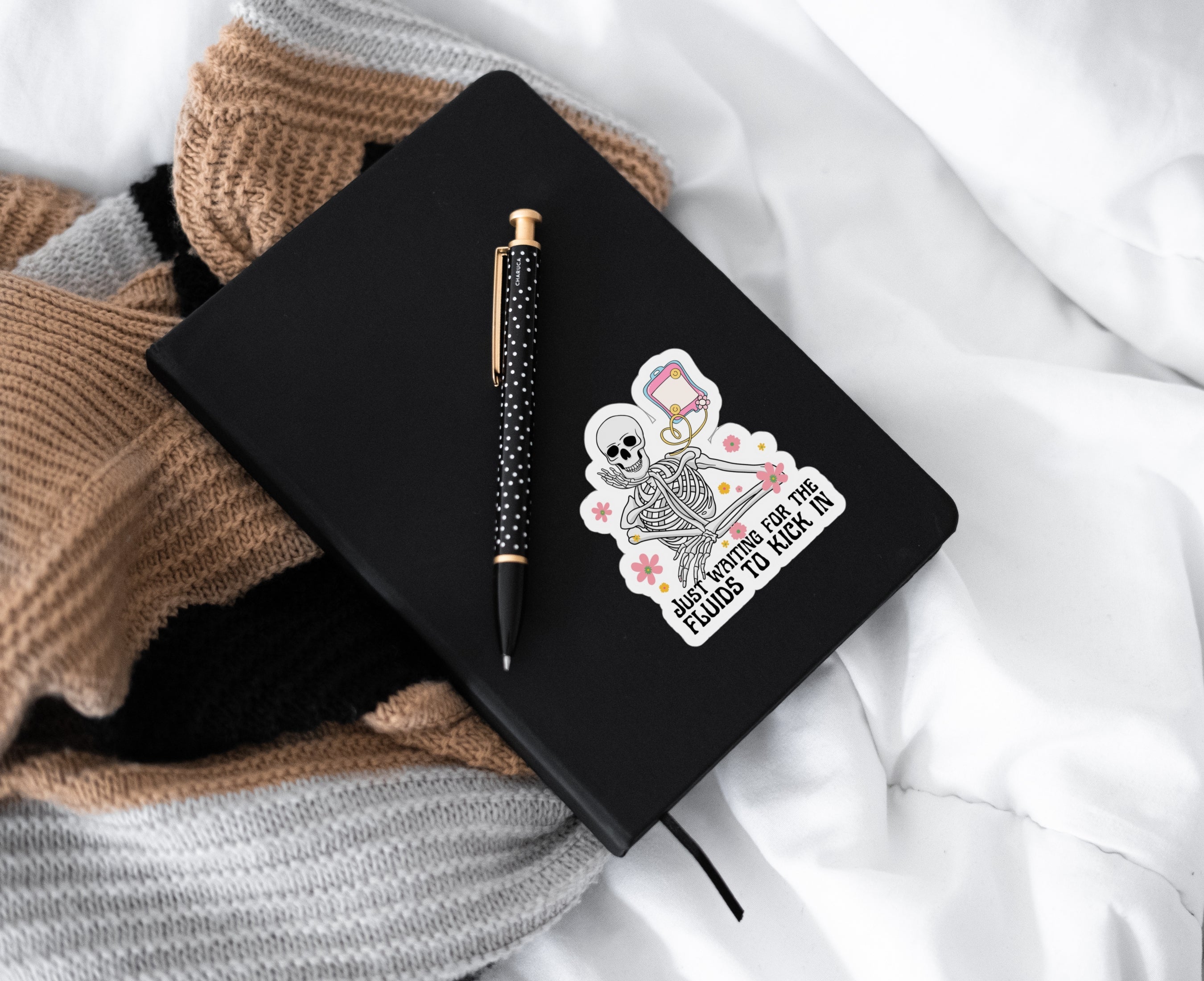 Sticker of skeleton getting fluids through IV bag on notebook