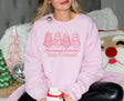 Girl wearing pink sweatshirt with pink Christmas tree cakes on it