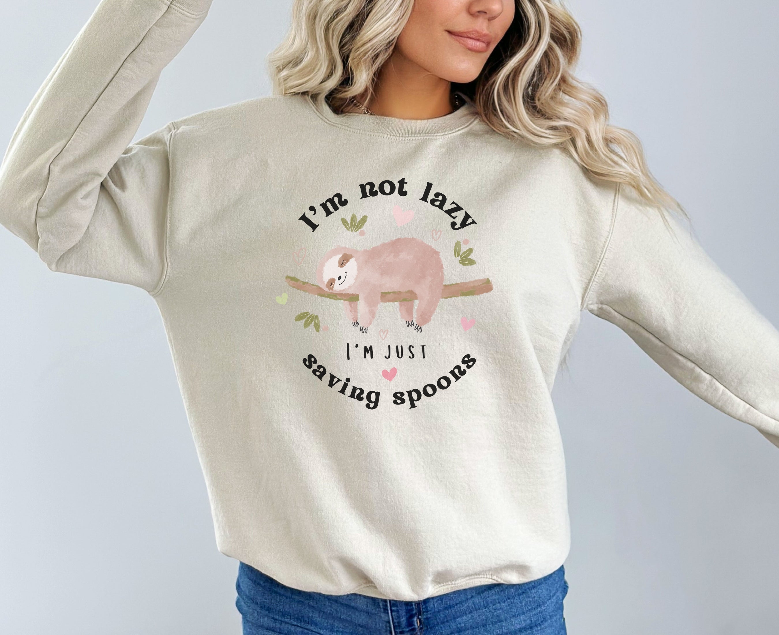 Woman wearing sand sweatshirt with sleeping sloth on it