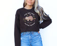 Woman wearing chocolate brown sweatshirt with sleeping sloth on it
