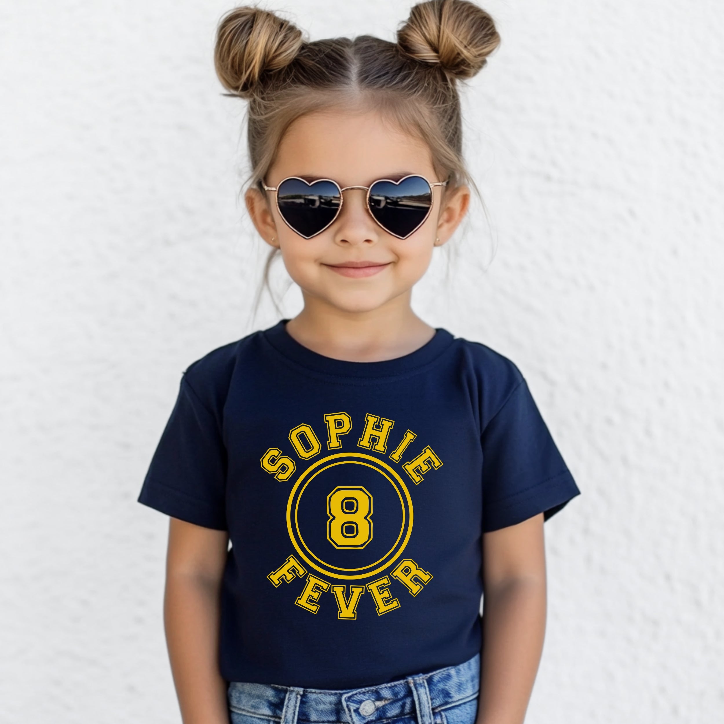 Child wearing a navy blue t-shirt with 'Sophie 8 Fever' text, heart-shaped sunglasses, and denim shorts on a white background.