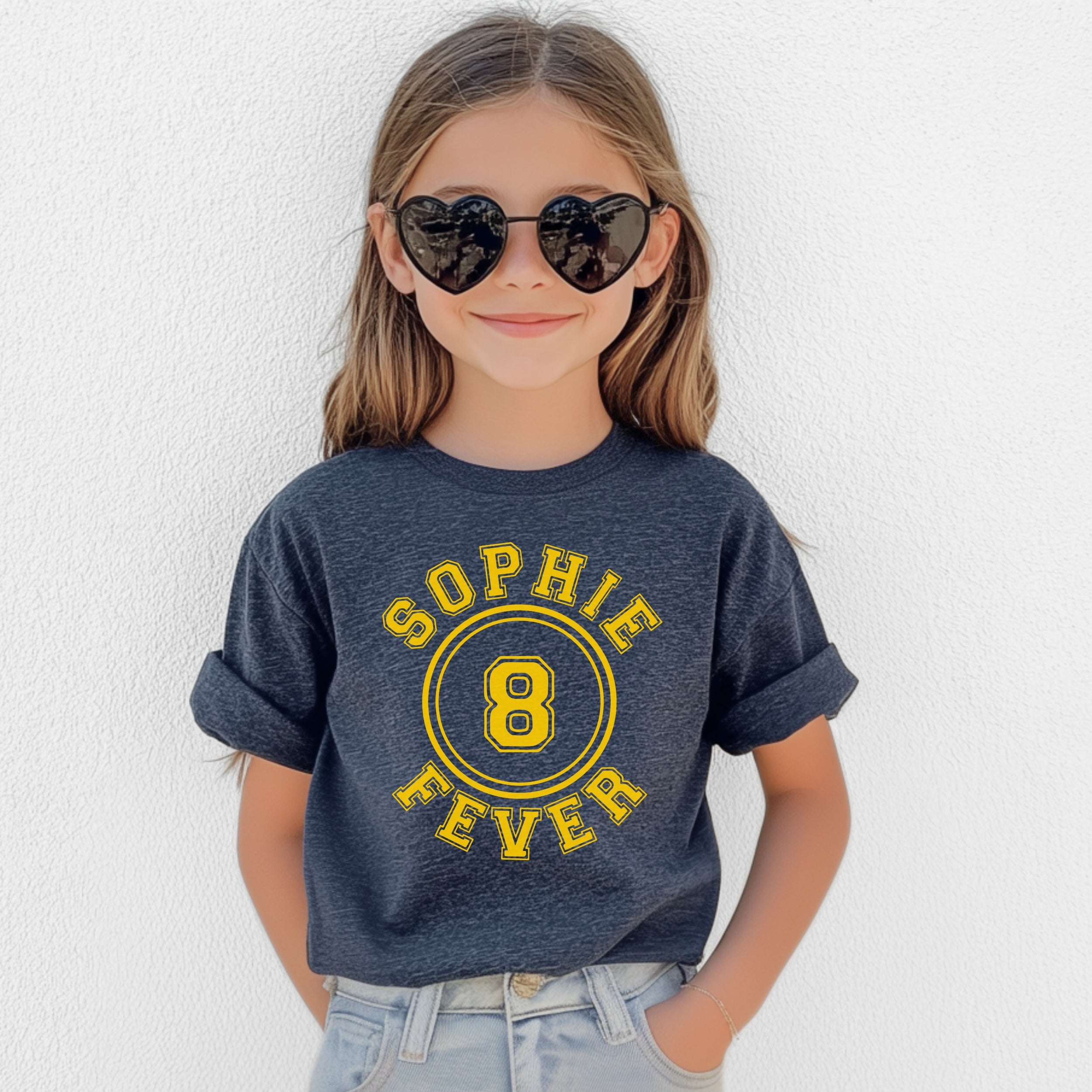 Child wearing a blue t-shirt with 'Sophie 8 Fever' text, heart-shaped sunglasses, and light blue jeans against a white background.