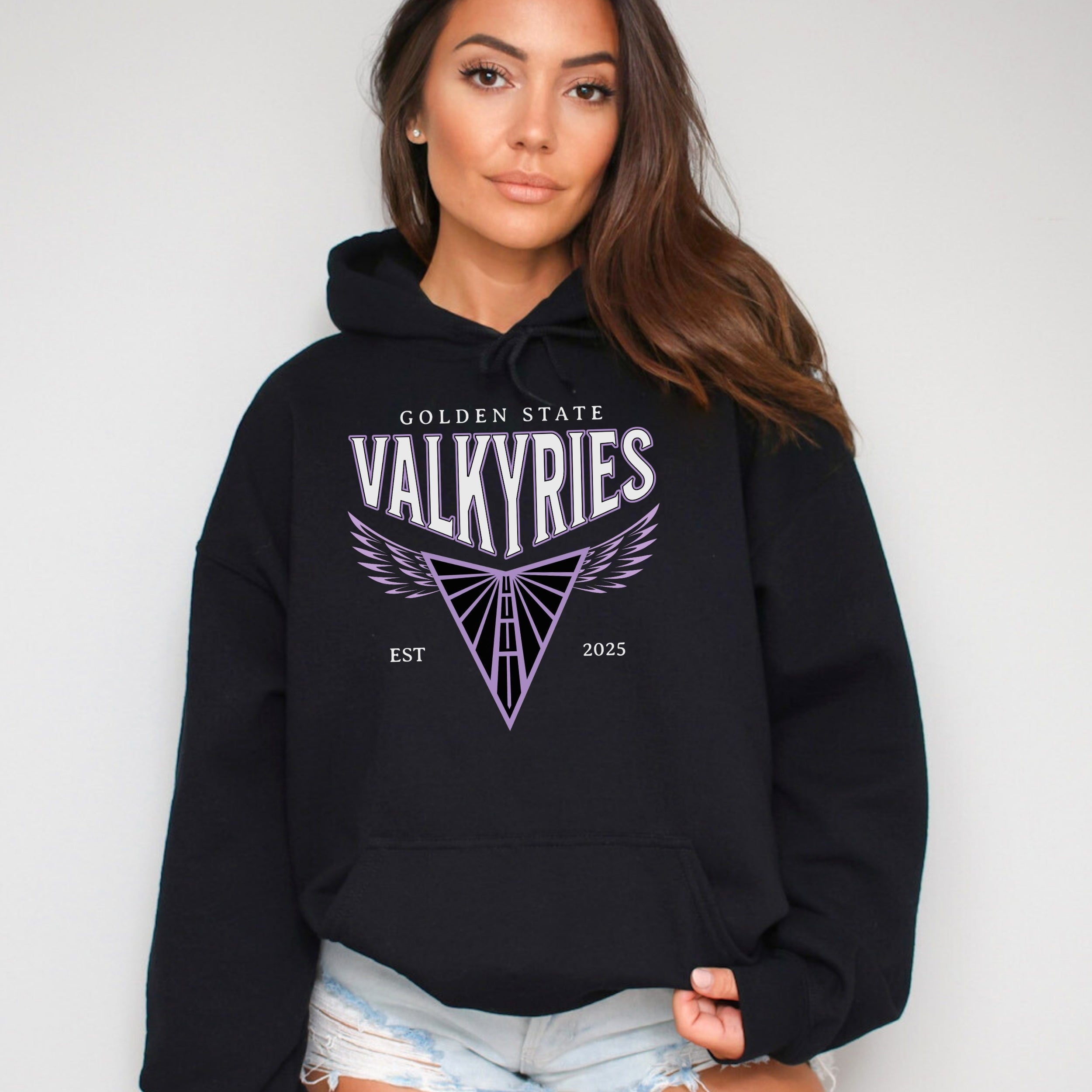 Woman wearing a black hoodie with 'Golden State Valkyries' logo on a plain background