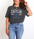 Person wearing a dark gray t-shirt with 'Indiana Fever Caitlin 22' text, standing against a plain background.