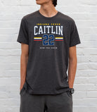 Person wearing a dark gray t-shirt with 'Indiana Fever Caitlin 22' text against a white brick wall.