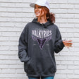 Woman wearing a gray hoodie with 'Golden State Valkyries' design against a white brick wall.