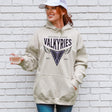 Person wearing a beige hoodie with 'Golden State Valkyries' design against a white brick wall.