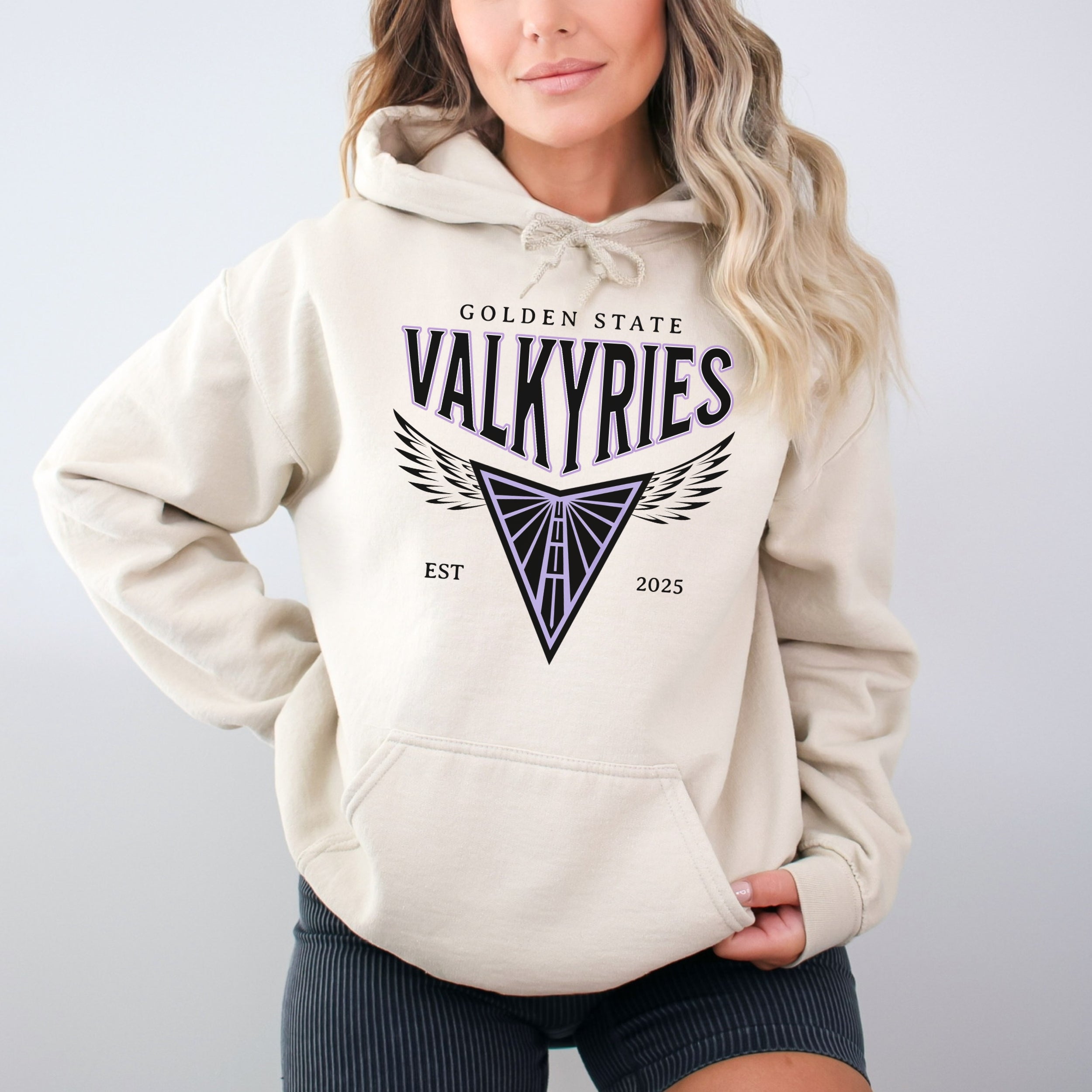 Person wearing a beige hoodie with 'Golden State Valkyries' logo on a plain background