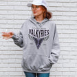 Person wearing a gray hoodie with 'Golden State Valkyries' text and logo against a white brick wall.