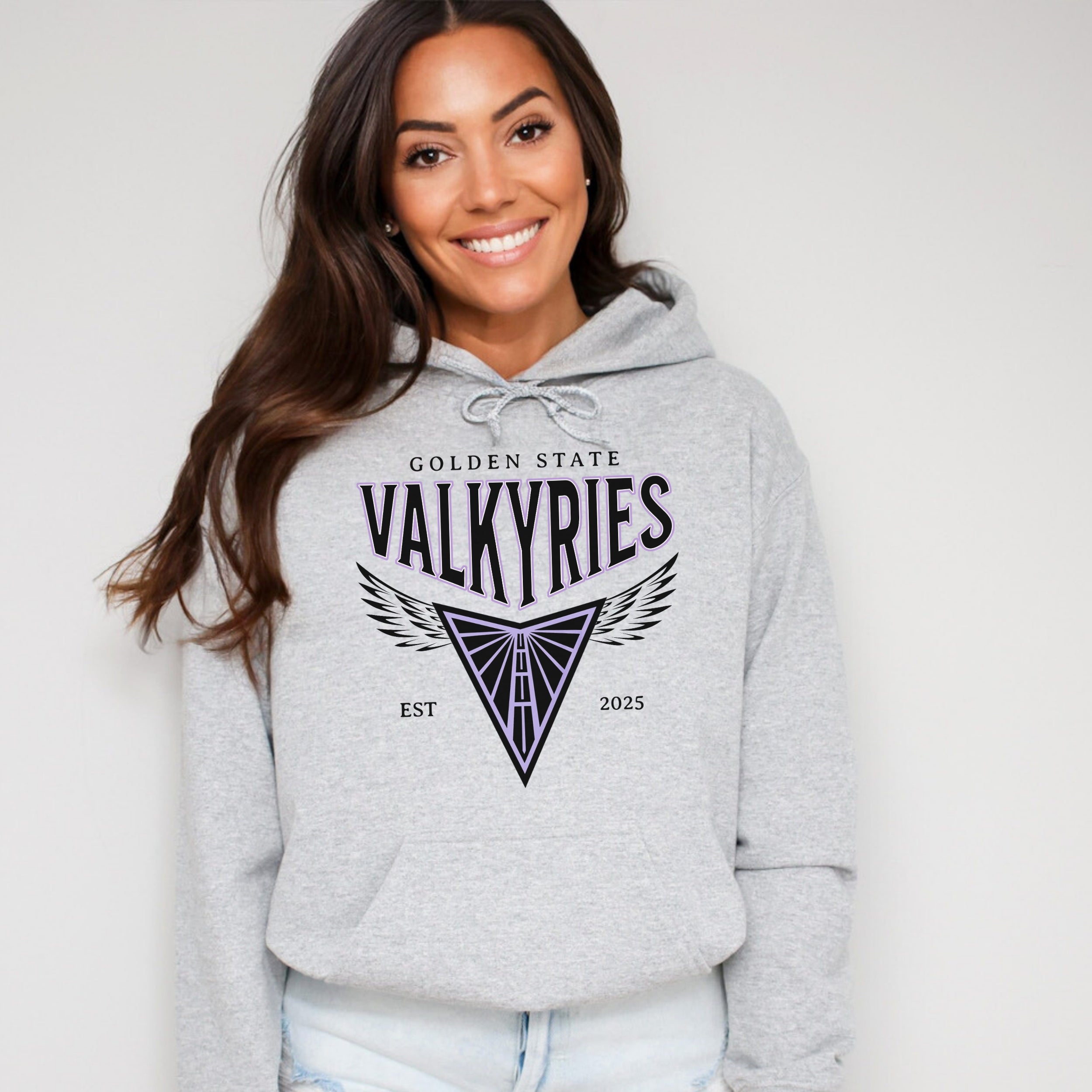 Woman wearing a gray hoodie with 'Golden State Valkyries' logo on a white background