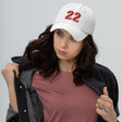 Girl wearing white number 22 dad hat